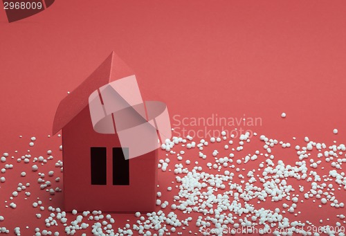 Image of paper house in snow on red background