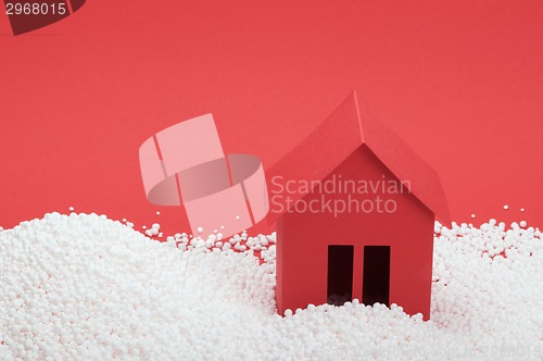 Image of paper house in snow on red background