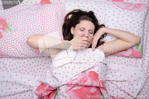 Image of The girl woke up yawning in bed