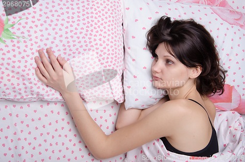 Image of Young girl misses her boyfriend in bed
