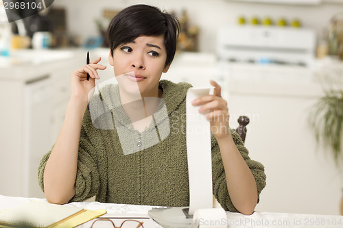 Image of Multi-ethnic Young Woman Agonizing Over Financial Calculations