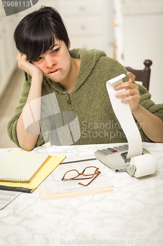 Image of Multi-ethnic Young Woman Agonizing Over Financial Calculations