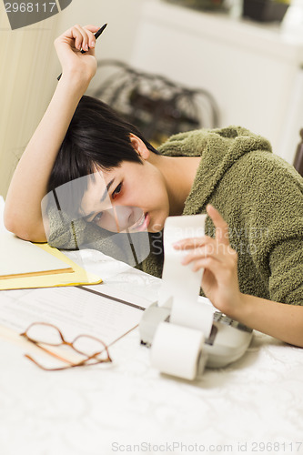 Image of Multi-ethnic Young Woman Agonizing Over Financial Calculations