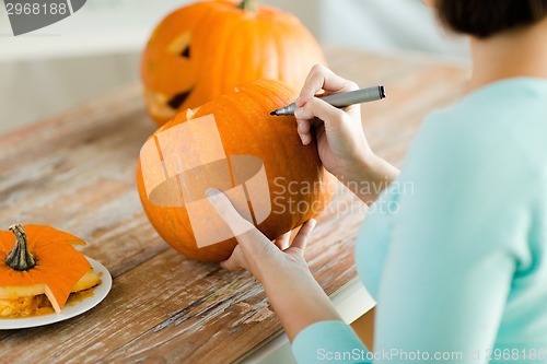 Image of close up of woman with pumpkins at home