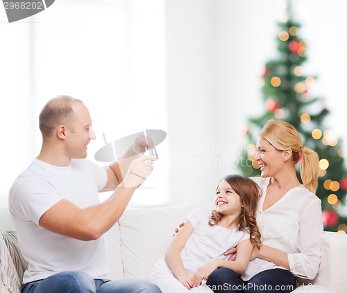 Image of happy family with camera at home