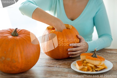Image of close up of woman with pumpkins at home
