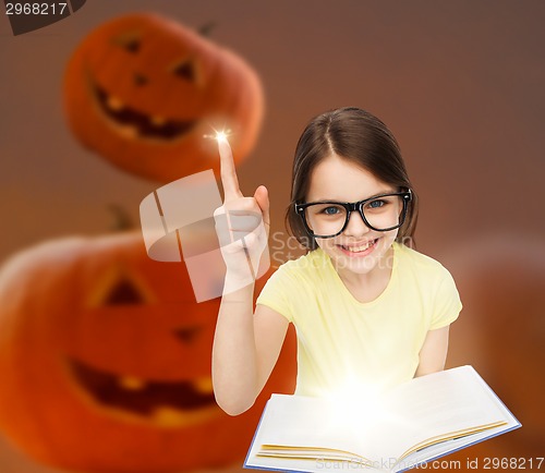 Image of smiling girl in glasses over pumpkins background
