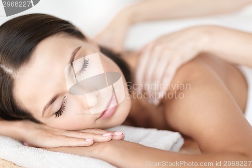 Image of beautiful woman in spa salon getting massage