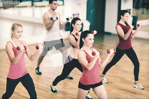 Image of group of smiling people working out with dumbbells