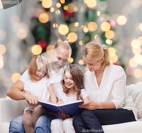 Image of happy family with book at home