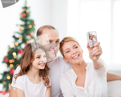 Image of happy family with camera at home