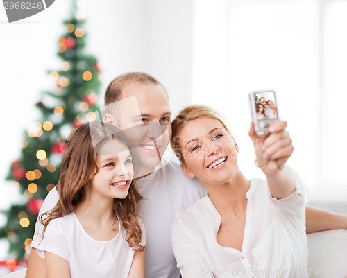 Image of happy family with camera at home