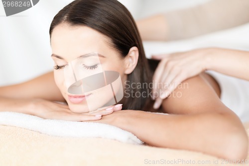 Image of beautiful woman in spa salon getting massage