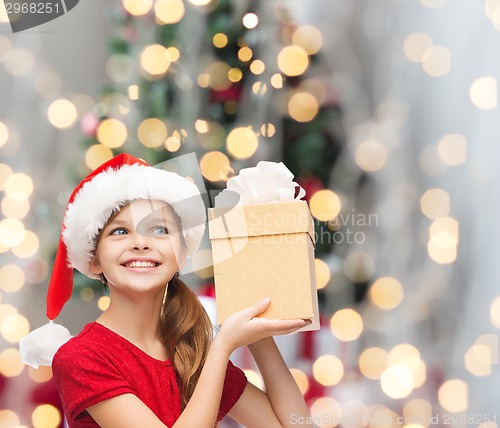 Image of smiling girl in santa helper hat with gift box