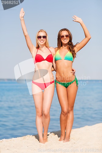 Image of two smiling young women on beach