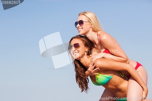 Image of two smiling young women on beach