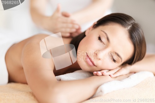 Image of beautiful woman in spa salon getting massage