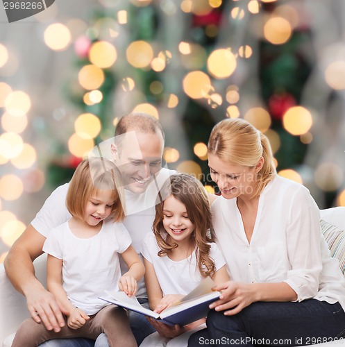 Image of happy family with book at home