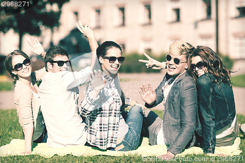 Image of group of students or teenagers waving hands