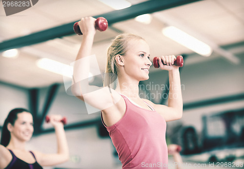 Image of group of smiling people working out with dumbbells