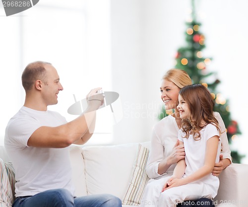 Image of happy family with camera at home