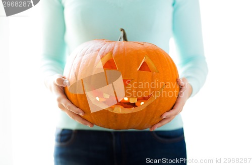 Image of close up of woman with pumpkins at home