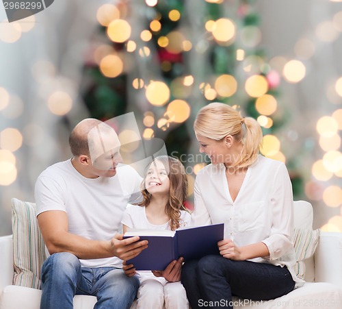 Image of happy family with book at home