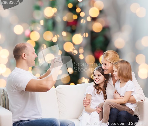 Image of happy family with camera at home