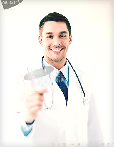 Image of young male doctor with pack of pills