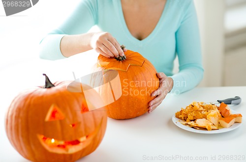 Image of close up of woman with pumpkins at home