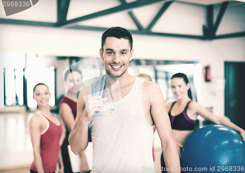 Image of smiling man standing in front of the group in gym