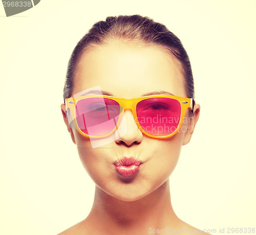 Image of girl in pink sunglasses blowing kiss