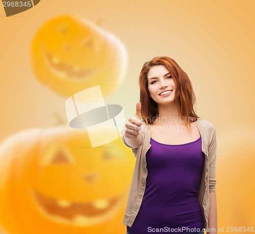Image of smiling teenage girl showing thumbs up