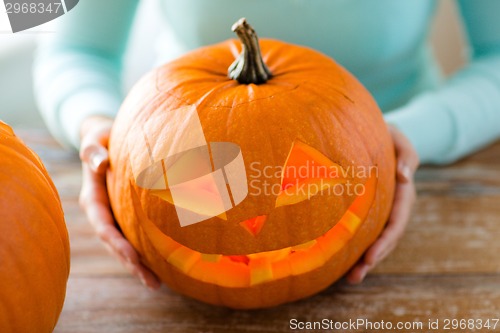 Image of close up of woman with pumpkins at home