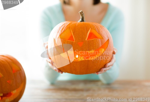 Image of close up of woman with pumpkins at home