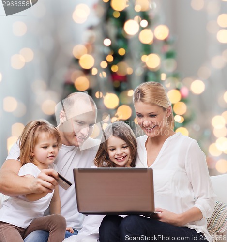 Image of happy family with laptop computer and credit card