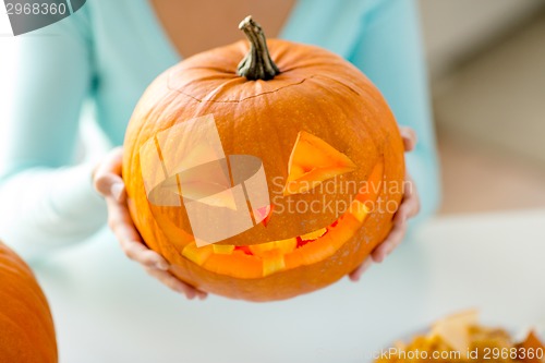 Image of close up of woman with pumpkins at home