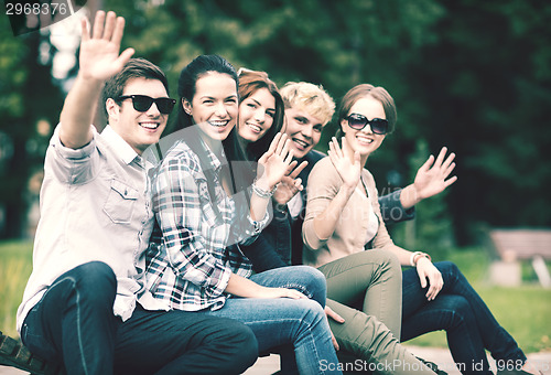 Image of group of students or teenagers waving hands