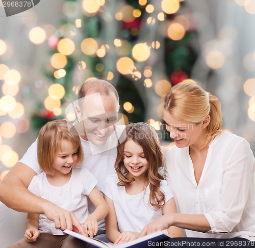 Image of happy family with book at home