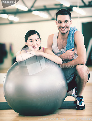 Image of two smiling people with fitness ball