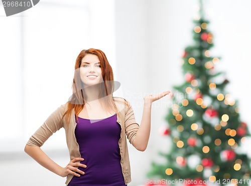 Image of smiling teenage girl holding something on her palm