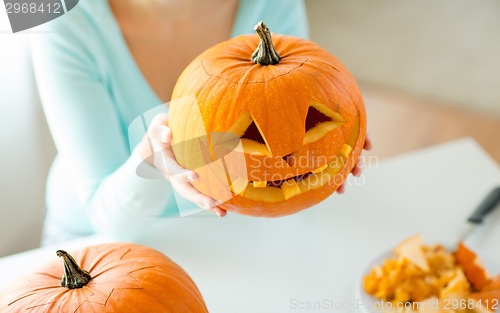 Image of close up of woman with pumpkins at home