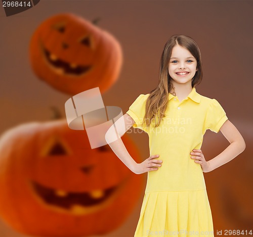 Image of smiling girl in dress over pumpkins background