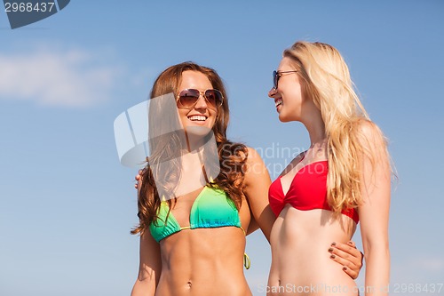 Image of two smiling young women on beach