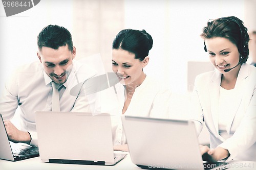 Image of group of people working with laptops in office