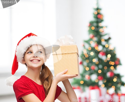 Image of smiling girl in santa helper hat with gift box