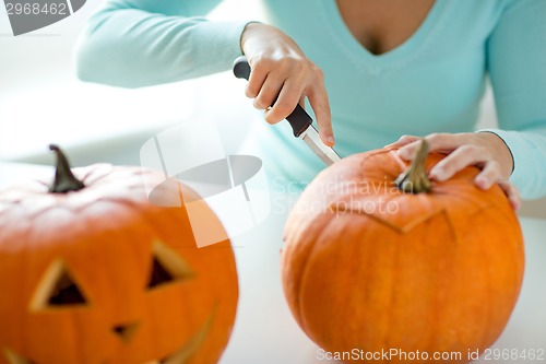 Image of close up of woman with pumpkins at home