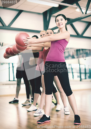 Image of group of smiling people working out with ball