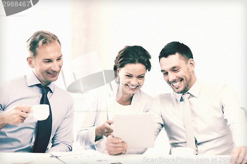 Image of business team having fun with tablet pc in office