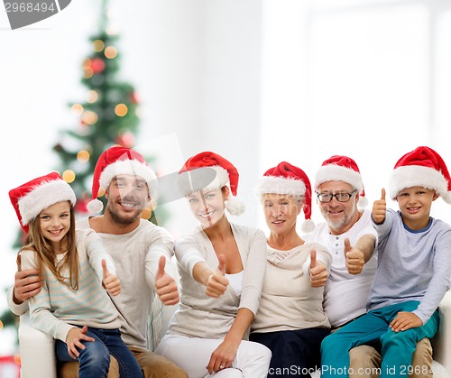 Image of happy family in santa hats showing thumbs up